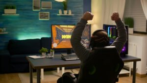 Videogamer player raising hands after winning